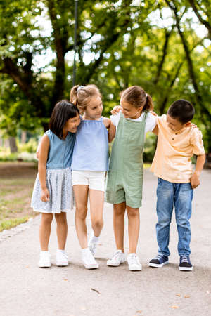 Group of cute asian and caucasian kids having fun in the park
