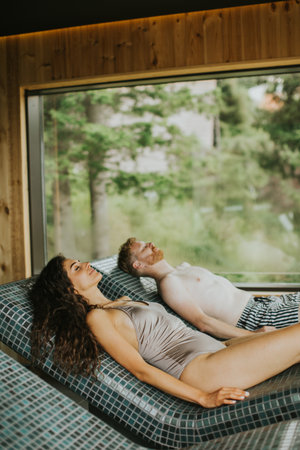 young couple relaxing on the tepidarium bed in the spaの写真素材