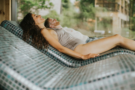 young couple relaxing on the tepidarium bed in the spa