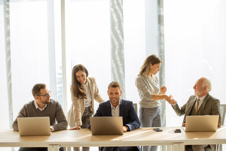 Handsome senior businessman working together with young business people in the officeの写真素材