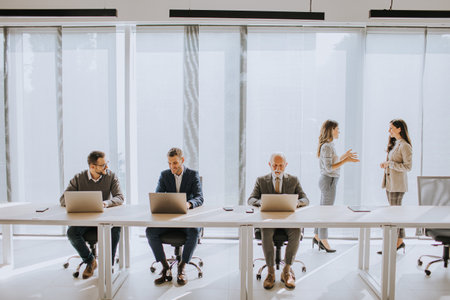 Handsome senior businessman working together with young business people in the officeの写真素材