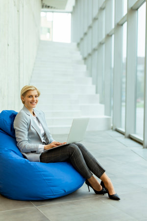 Businesswoman working on laptop on lazy bag in the modern officeの写真素材