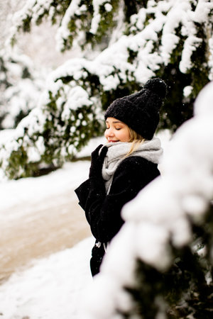 Pretty young woman n warm clothes enjoying in snowの写真素材