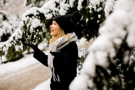 Pretty young woman n warm clothes enjoying in snow