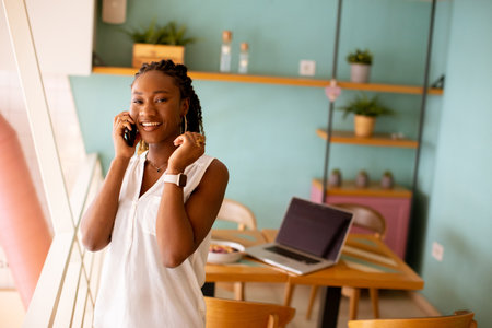 Pretty young black woman using mobile phone in the cafeの写真素材