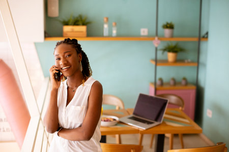 Pretty young black woman using mobile phone in the cafeの写真素材