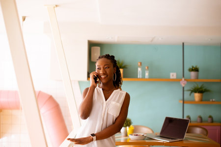 Pretty young black woman using mobile phone in the cafeの写真素材