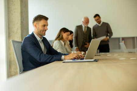 Handsome young business man using laptop computer in the office