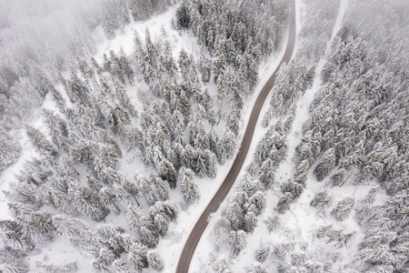 Drone view at mountain road at snowy winterの写真素材