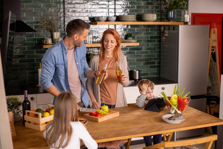 Happy young family preparing vegetables in the kitchenの写真素材