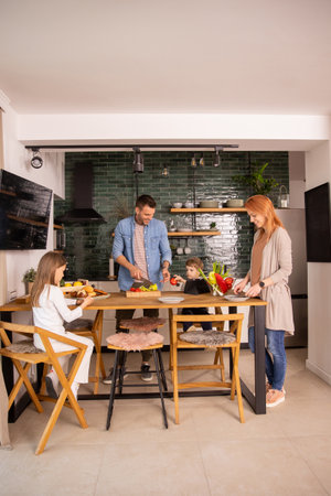 Happy young family preparing vegetables in the kitchenの写真素材