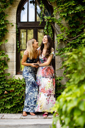 Pretty young women using mobile phone by old house with ivyの写真素材