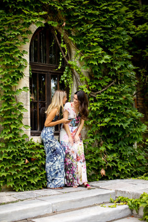 Pretty young women using mobile phone by old house with ivyの写真素材