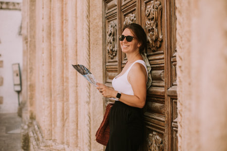 Female tourist with a city map by the church San Francesco dâAssisi in Ostuni, Italyの写真素材