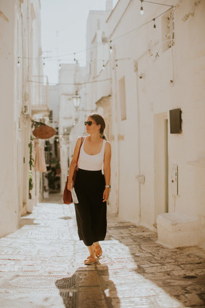 Female tourist with a paper city map on narrow streets of Ostuni, Italyの写真素材