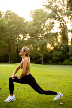 Pretty young woman doing stretching in the parkの写真素材