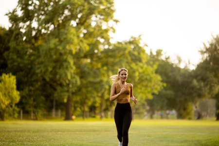 Pretty young woman running in parkの写真素材