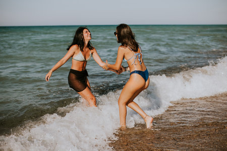 Two pretty young woman having fun on the seaside at hot summer dayの写真素材