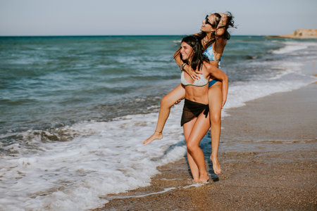 Two pretty young woman having fun on the seaside at hot summer dayの写真素材
