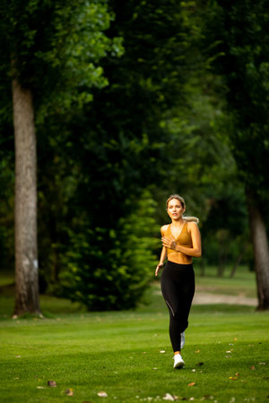 Pretty young woman running in parkの写真素材