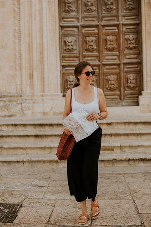 Female tourist with a city map by the church San Francesco dâAssisi in Ostuni, Italyの写真素材