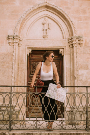 Female tourist with a city map by the church San Francesco dâAssisi in Ostuni, Italyの写真素材