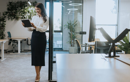 Young business woman with digital tablet standing in the modern officeの写真素材