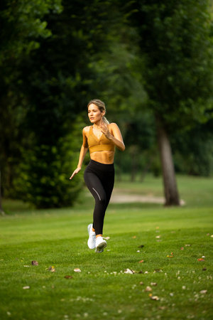 Pretty young woman running in parkの写真素材