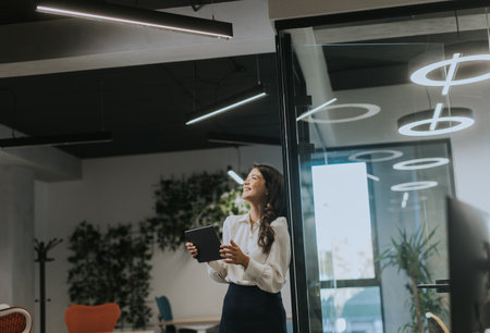 Young business woman with digital tablet standing in the modern officeの写真素材