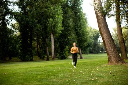 Pretty young woman running in parkの写真素材