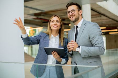 Young business couple holding digital tablet and discussing company strategyの写真素材