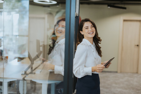 Young business woman with digital tablet standing in the modern officeの写真素材
