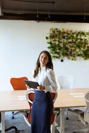 Young business woman with digital tablet standing in the modern officeの写真素材