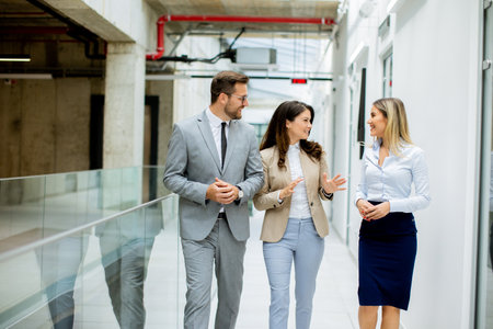 Young startup team have a discussion while walking in the office corridorの写真素材