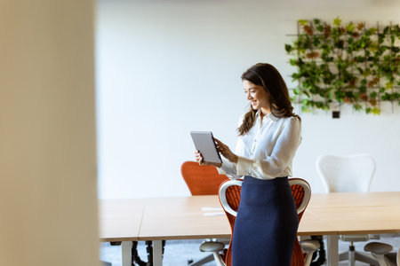 Young business woman with digital tablet standing in the modern officeの写真素材