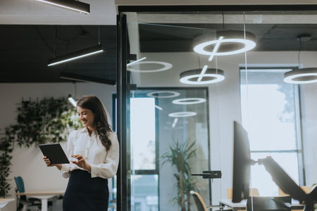 Young business woman with digital tablet standing in the modern officeの写真素材