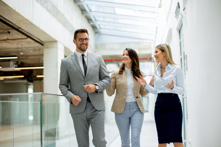 Young startup team have a discussion while walking in the office corridorの写真素材