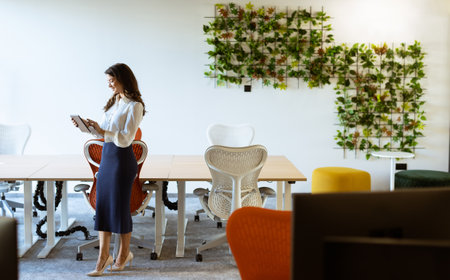 Young business woman with digital tablet standing in the modern officeの写真素材