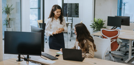 Young business women discussing in cubicle at the modern officeの写真素材