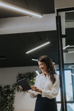 Young business woman with digital tablet standing in the modern officeの写真素材