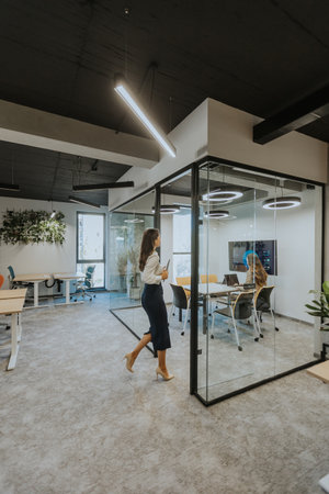 Young business woman with digital tablet walking in the modern officeの写真素材
