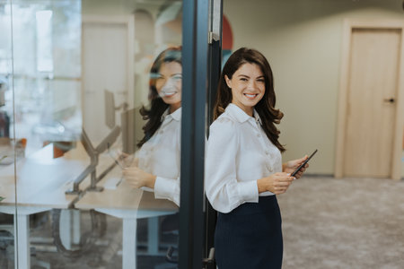 Young business woman with digital tablet standing in the modern officeの写真素材