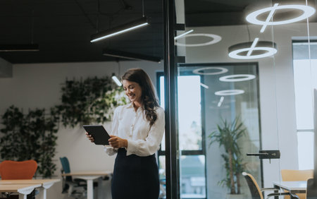 Young business woman with digital tablet standing in the modern officeの写真素材