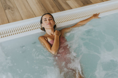 Pretty young woman relaxing in the indoor swimming poolの写真素材