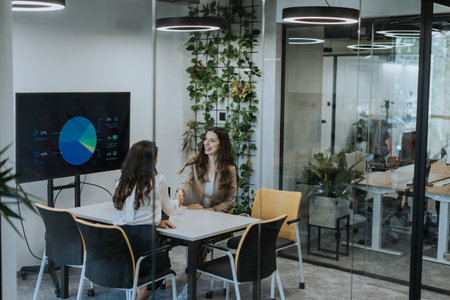 Young business women discussing in cubicle at the modern office