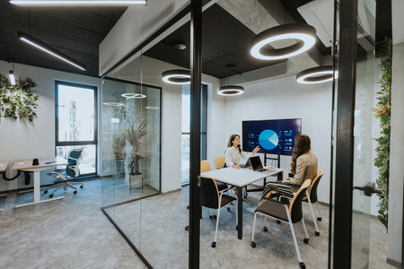Young business women discussing in cubicle at the modern office