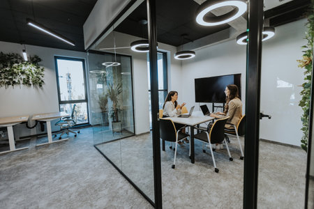 Young business women discussing in cubicle at the modern officeの写真素材