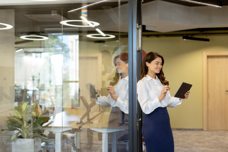 Young business woman with digital tablet standing in the modern officeの写真素材