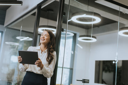 Young business woman with digital tablet standing in the modern officeの写真素材