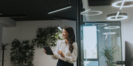 Young business woman with digital tablet standing in the modern officeの写真素材